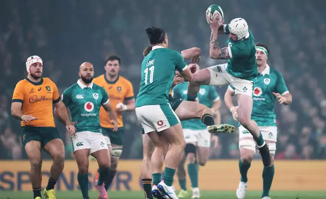 Ireland's Mack Hansen, top right, jumps for the ball during the rugby union Nations Series match between Ireland and Australia in Dublin, Saturday, Nov. 15, 2025. (AP Photo/Peter Morrison)