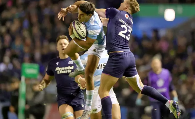 Argentina's Santiago Carreras, left, and Scotland's Duhan van der Merwe challenge of a high ball during the rugby union Nations Series match between Scotland and Argentina in Edinburgh, Sunday, Nov. 16, 2025. (Steve Welsh/PA via AP)