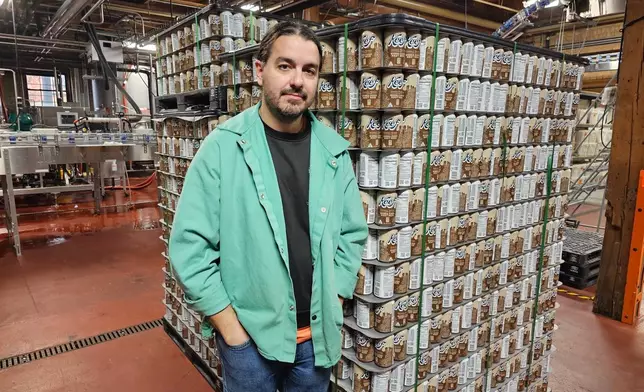 Ryan Bandy, chief business officer at Indeed Brewing in Minneapolis, stands near a pallet of six-packs of seltzer containing THC, the active ingredient in marijuana, in his brewery on Thursday, Nov. 20, 2025. (AP Photo/Steve Karnowski)