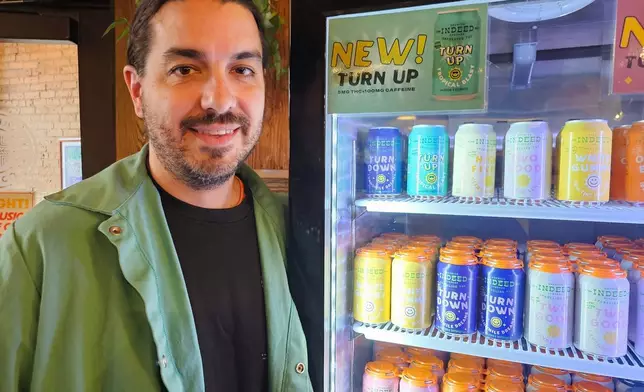 Ryan Bandy, chief business officer at Indeed Brewing in Minneapolis, stands outside a cooler for cans of seltzer containing THC, the active ingredient in marijuana, in his brewery's taproom on Thursday, Nov. 20, 2025. (AP Photo/Steve Karnowski)