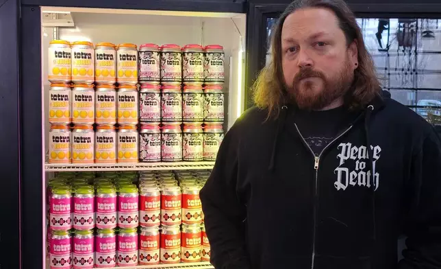 Drew Hurst, president and chief operating officer of Bauhaus Brew Labs in Minneapolis, stands outside a cooler for cans of seltzer containing THC, the active ingredient in marijuana, in his brewery's taproom on Thursday, Nov. 20, 2025. (AP Photo/Steve Karnowski)