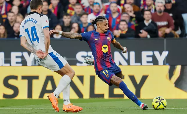 Barcelona's Raphinha, right, duels for the balls with Alaves' Nahuel Tenaglia during a Spanish La Liga soccer match between Barcelona and Alaves, in Barcelona, Spain, Saturday, Nov. 29, 2025. (AP Photo/Joan Monfort)