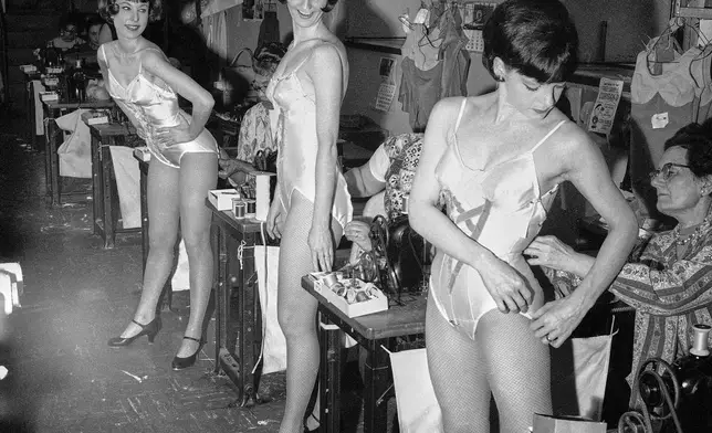 FILE — Rockettes Louise Thompson of Long Beach, Calif., from left, Judy Little of Camden, N.J., and Joyce Hector of West Orange, N.J., are fitted for costumes for a new show in the Radio City Music Hall's costuming department, April 5, 1966, in New York. (AP Photo/Anthony Camerano, File)