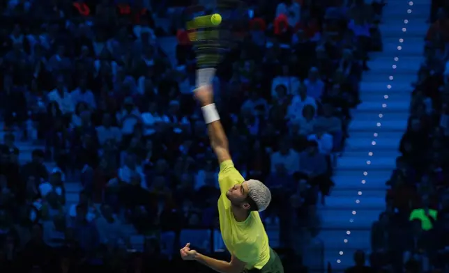 Spain's Carlos Alcaraz serves to Italy's Jannik Sinner during the final tennis match of the ATP World Tour Finals, in Turin, Italy, Sunday, Nov. 16, 2025. (AP Photo/Antonio Calanni)
