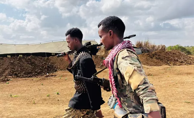 Somalia National Army (SNA) soldiers walk along the frontline in Sabiid, Canole, Somalia, Tuesday, Nov. 11, 2025. (AP Photo/Jackson Njehia)