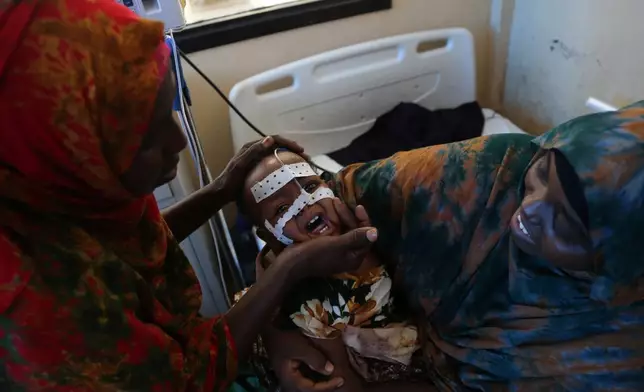 A mother sits with her malnourished baby at Banadir Hospital in Mogadishu, Somalia, Tuesday, Nov. 11, 2025. (AP Photo/Farah Abdi Warsameh)
