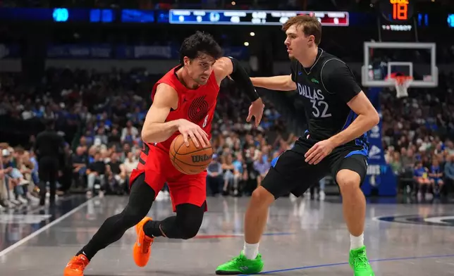Portland Trail Blazers forward Deni Avdija (8) drives to the basket against Dallas Mavericks forward Cooper Flagg (32) during the first half of an NBA basketball game Sunday, Nov. 16, 2025, in Dallas. (AP Photo/Julio Cortez)