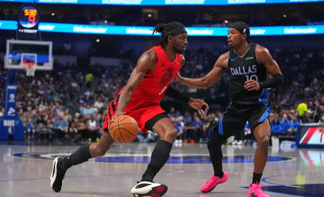 Portland Trail Blazers forward Jerami Grant, left, drives to the basket against Dallas Mavericks guard Brandon Williams during the first half of an NBA basketball game Sunday, Nov. 16, 2025, in Dallas. (AP Photo/Julio Cortez)