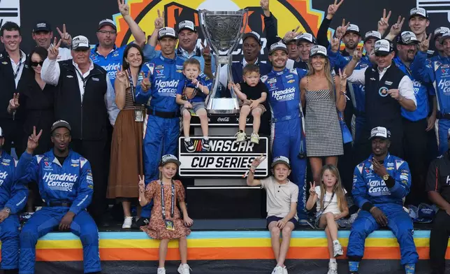 Kyle Larson celebrates with family and teammates after winning the NASCAR Cup Series championship Sunday, Nov. 2, 2025, in Avondale, Ariz. (AP Photo/Rick Scuteri)