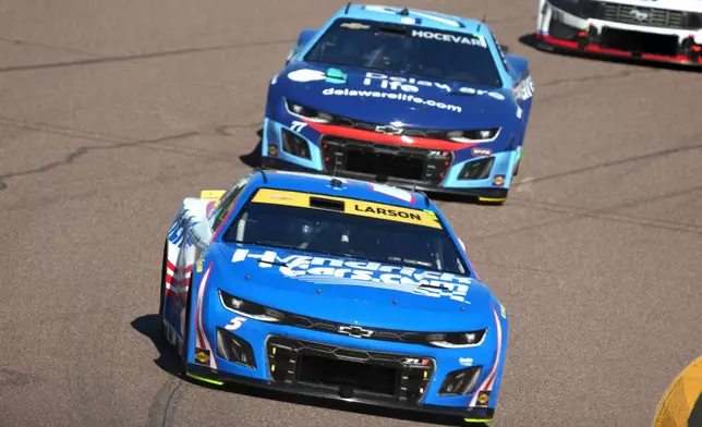 Kyle Larson (5) races with Carson Hocevar during a NASCAR Cup Series auto race Sunday, Nov. 2, 2025, in Avondale, Ariz. (AP Photo/Rick Scuteri)