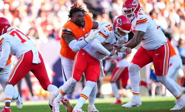 Denver Broncos defensive tackle Malcolm Roach loses his helmet while pursuing Kansas City Chiefs quarterback Patrick Mahomes (15) during the first half an NFL football game Sunday, Nov. 16, 2025, in Denver. (AP Photo/Jack Dempsey)