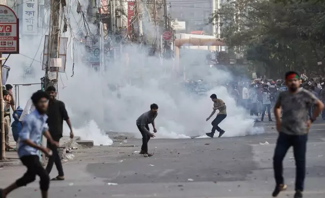 Protesters throw stones and shout slogans during a standoff with police outside the demolished residence of Sheikh Mujibur Rahman, Bangladesh's former leader and the father of the country's ousted Prime Minister Sheikh Hasina following the verdict against her, in Dhaka, Bangladesh, Monday, Nov. 17, 2025. (AP Photo/ Rajib Dhar)