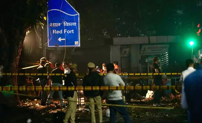 Security officers inspect the site of a car explosion near the historic Red Fort in New Delhi, India, Monday, Nov. 10, 2025. (AP Photo/Manish Swarup)