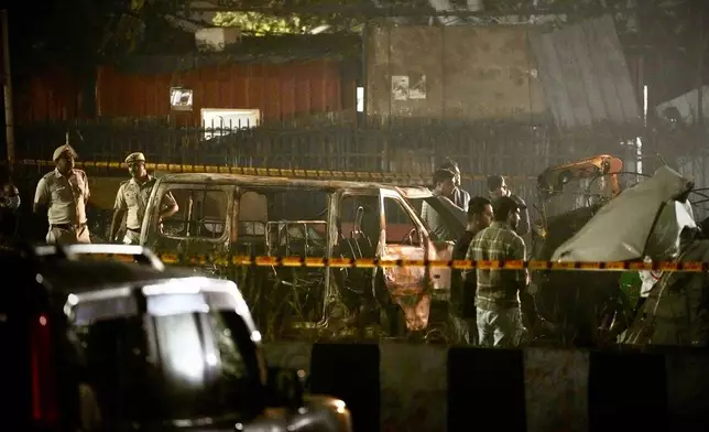Security officials inspect damaged vehicles at the site after a car explosion near the historic Red Fort in New Delhi, India, Monday, Nov. 10, 2025. (AP Photo/Manish Swarup)