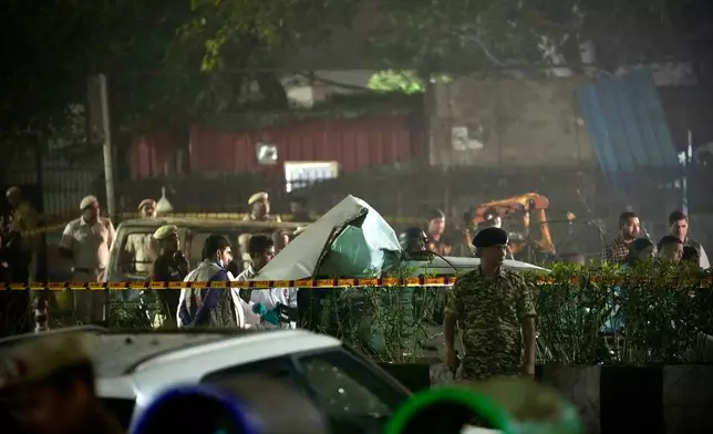 Security officials inspect damaged vehicles at the site after a car explosion near the historic Red Fort in New Delhi, India, Monday, Nov. 10, 2025. (AP Photo/Manish Swarup)