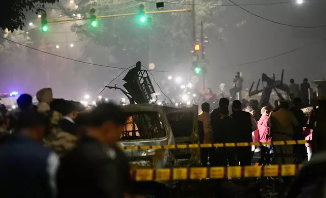 Officials inspect damaged vehicles at the site after a car explosion near the historic Red Fort in New Delhi, India, Monday, Nov. 10, 2025. (AP Photo/Manish Swarup)