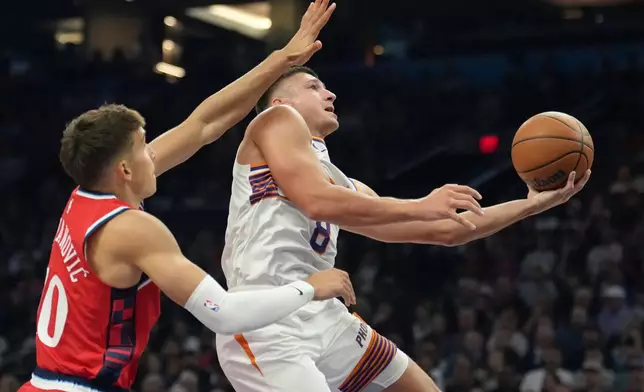Phoenix Suns guard Grayson Allen (8) drives past Los Angeles Clippers guard Bogdan Bogdanovic, left, to score during the first half of an NBA basketball game Thursday, Nov. 6, 2025, in Phoenix. (AP Photo/Ross D. Franklin)