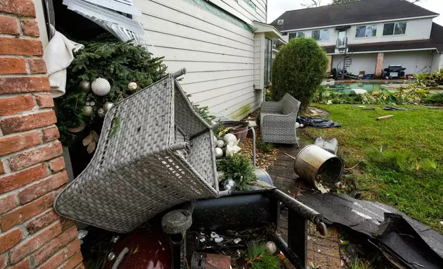 A Christmas tree was sucked out the back window of Guillermo Vargas' home after at storm swept through the Memorial Northwest subdivision, in Spring, Texas, Monday, Nov. 24, 2025. (Brett Coomer/Houston Chronicle via AP)