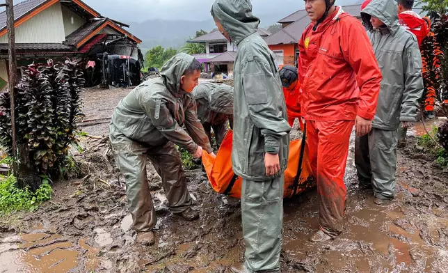 Rescuers carry the body of a flood victim in Malalak, West Sumatra, Indonesia, Friday, Nov. 28, 2025. (AP Photo/Ade Yuandha)