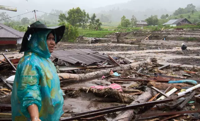 A woman inspects the damage after a flood in Malalak, West Sumatra, Indonesia, Thursday, Nov. 27, 2025. (AP Photo/Ade Yuandha)