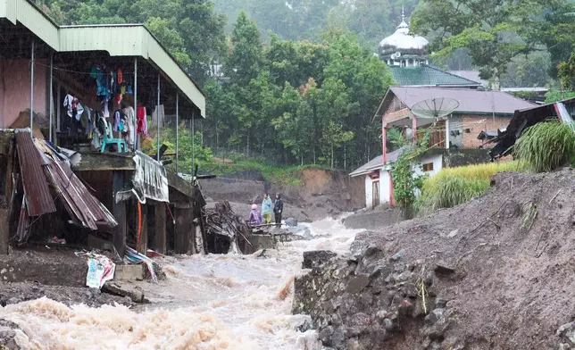 Residents inspect the damage after a flood in Malalak, West Sumatra, Indonesia, Thursday, Nov. 27, 2025. (AP Photo/Ade Yuandha)