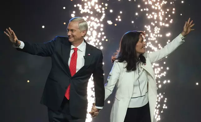 Presidential candidate Jose Antonio Kast, left, of the Republican Party and his wife Maria Pia Adriasola wave to supporters at a campaign rally ahead of general elections, in Santiago, Chile, Tuesday, Nov. 11, 2025. (AP Photo/Esteban Felix)