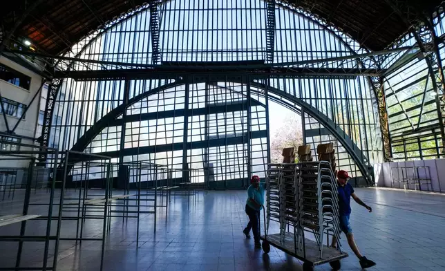 Electoral workers prepare the old Mapocho train station, now a cultural center, to be used as a polling station for the general election in Santiago, Chile, Friday, Nov. 14, 2025. (AP Photo/Esteban Felix)