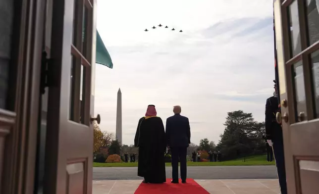 President Donald Trump and Saudi Arabia's Crown Prince Mohammed bin Salman watch a flight of F-35's and F-15's during a welcome ceremony on the South Lawn of the White House, Tuesday, Nov. 18, 2025, in Washington. (AP Photo/Evan Vucci)