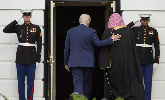 President Donald Trump escorts Saudi Arabia's Crown Prince Mohammed bin Salman into the White House, Tuesday, Nov. 18, 2025, in Washington. (AP Photo/Mark Schiefelbein)