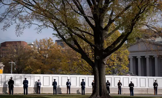 Members of an honor guard stand along a fence next to a construction zone at the White House prior to the arrival of Saudi Arabia's Crown Prince Mohammed bin Salman, Tuesday, Nov. 18, 2025, in Washington. (AP Photo/Mark Schiefelbein)