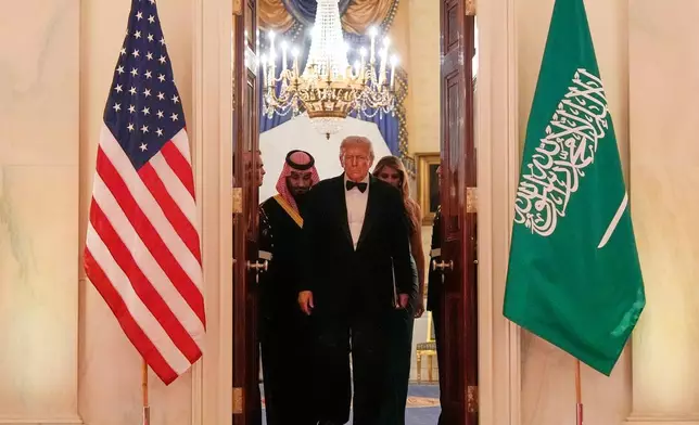 President Donald Trump, first lady Melania Trump and Saudi Arabia's Crown Prince Mohammed bin Salman arrive through the Blue Room for a dinner in the East Room of the White House, Tuesday, Nov. 18, 2025, in Washington. (AP Photo/Alex Brandon)