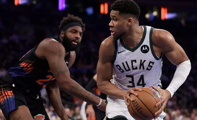 Milwaukee Bucks forward Giannis Antetokounmpo (34) looks to drive past New York Knicks center Mitchell Robinson during the first half of an NBA basketball game, Friday, Nov. 28, 2025, in New York. (AP Photo/Adam Hunger)