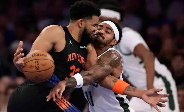 Milwaukee Bucks guard Gary Harris, right, defends a driving New York Knicks center Karl-Anthony Towns during the first half of an NBA basketball game, Friday, Nov. 28, 2025, in New York. (AP Photo/Adam Hunger)