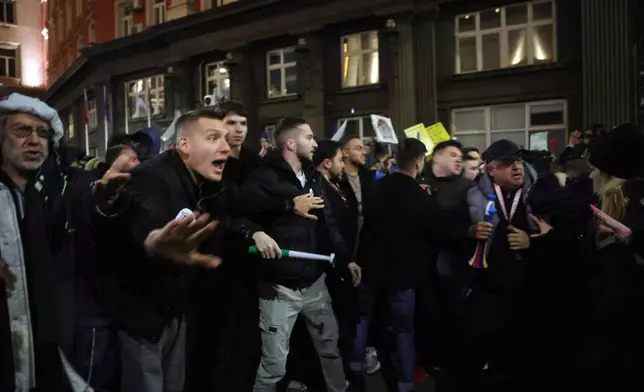 Protesters shout at policemen as thousands took to the streets of Bulgaria's capital, Sofia, to denounce steep tax hikes in next year's draft budget before being finally voted on in parliament, Wednesday, Nov 26, 2025. (AP Photo/Valentina Petrova)