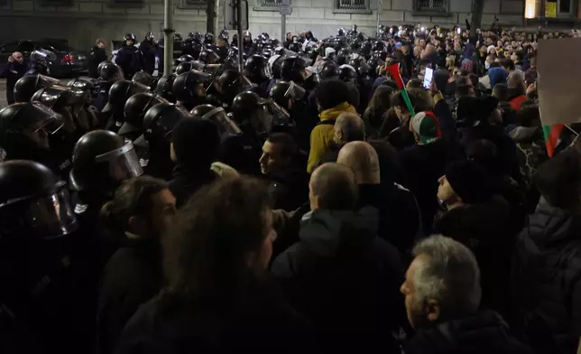 Protesters scuffle with police as thousands took to the streets of Bulgaria's capital, Sofia, to denounce steep tax hikes in next year's draft budget before being finally voted on in parliament, Wednesday, Nov 26, 2025. (AP Photo/Valentina Petrova)
