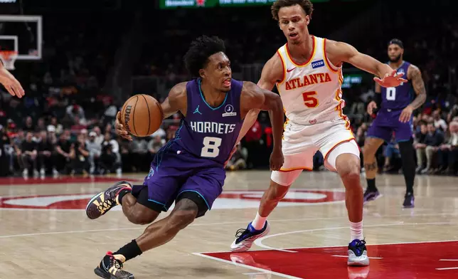 Charlotte Hornets guard Collin Sexton (8) drives to the basket against Atlanta Hawks guard Dyson Daniels (5) during the first half of an NBA basketball game, Sunday, Nov. 23, 2025, in Atlanta. (AP Photo/Colin Hubbard)