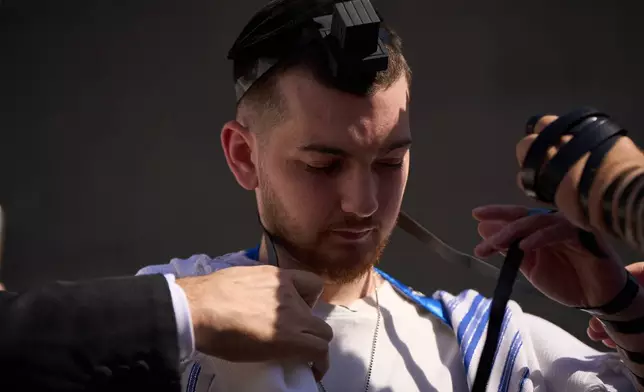 Freed Israeli hostage Bar Kupershtein, recently released from Hamas captivity in Gaza, attends a tefillin-laying ceremony at a plaza known as Hostages Square, in Tel Aviv, Israel, Friday, Oct. 31, 2025. (AP Photo/Oded Balilty)