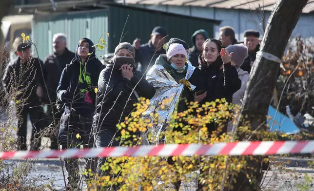 People react near a residential building which was heavily damaged by a Russian strike on Ternopil, Ukraine, on Wednesday, Nov. 19, 2025. (AP Photo/Vlad Kravchuk)