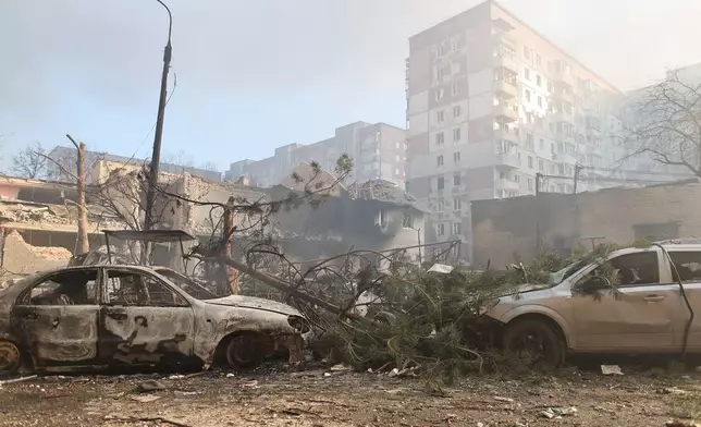 Burnt cars are seen in front of a residential building which was heavily damaged after a Russian strike on Ternopil, Ukraine, on Wednesday, Nov. 19, 2025. (AP Photo/Vlad Kravchuk)