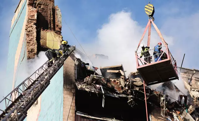 Rescue workers clear the rubble of a residential building which was heavily damaged by a Russian strike on Ternopil, Ukraine, on Wednesday, Nov. 19, 2025. (AP Photo/Vlad Kravchuk)