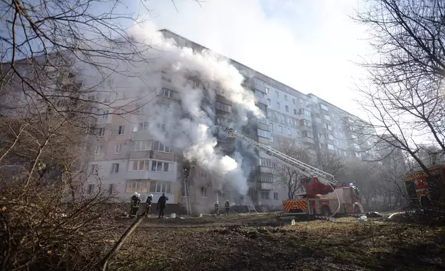 Rescue workers put out a fire of a residential building which was heavily damaged by a Russian strike on Ternopil, Ukraine, on Wednesday, Nov. 19, 2025. (AP Photo/Rostyslav Kovalchuk)