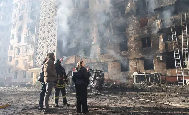 People look at a residential building which was heavily damaged after a Russian strike on Ternopil, Ukraine, on Wednesday, Nov. 19, 2025. (AP Photo/Vlad Kravchuk)