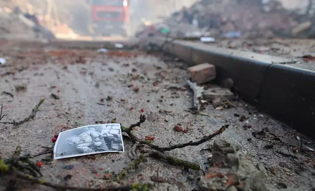 A photograph of a child lies on the ground near a residential building which was heavily damaged by a Russian strike on Ternopil, Ukraine, on Wednesday, Nov. 19, 2025. (AP Photo/Vlad Kravchuk)