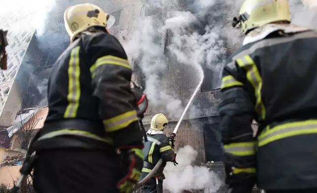 Rescue workers put out a fire of a residential building which was heavily damaged by a Russian strike, in Ternopil, Ukraine, Wednesday, Nov. 19, 2025. (AP Photo/Vlad Kravchuk)