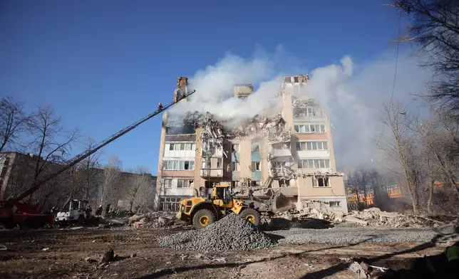 Rescue workers put out a fire of a residential building which was damaged by a Russian strike on Ternopil, Ukraine, on Wednesday, Nov. 19, 2025. (AP Photo/Rostyslav Kovalchuk)