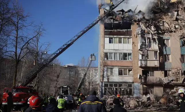 Rescue workers put out a fire of a residential building which was heavily damaged by a Russian strike on Ternopil, Ukraine, on Wednesday, Nov. 19, 2025. (AP Photo/Rostyslav Kovalchuk)