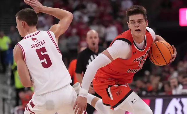 Campbell's Dovydas Butka tries to get past Wisconsin's Jack Janicki during the first half of an NCAA college basketball game Monday, Nov. 3, 2025, in Madison, Wis. (AP Photo/Morry Gash)