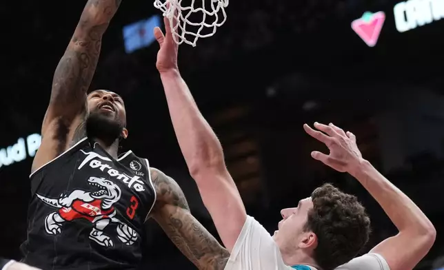 Toronto Raptors forward Brandon Ingram (3) dunks over Charlotte Hornets center Ryan Kalkbrenner (11) during second-half NBA basketball game action in Toronto, Monday, Nov. 17, 2025. (Nathan Denette/The Canadian Press via AP)