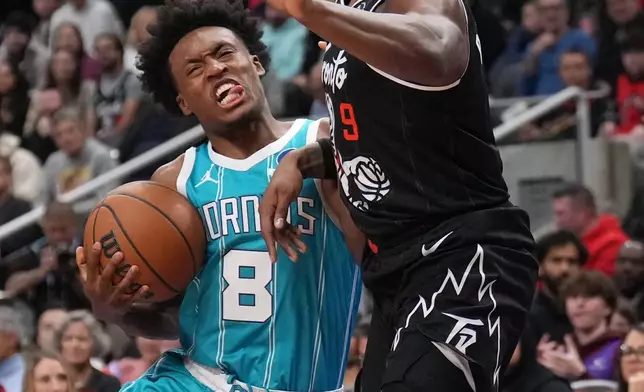 Toronto Raptors forward/guard RJ Barrett (9) fouls Charlotte Hornets guard Collin Sexton (8) during the first half of an NBA basketball game in Toronto on Monday, Nov. 17, 2025. (Nathan Denette/The Canadian Press via AP)
