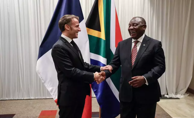 France's President Emmanuel Macron, left, shakes hands with South Africa's President Cyril Ramaphosa during their bilateral meeting at the Sandton Convention Centre in Sandton, South Africa, Friday Nov. 21, 2025, ahead of the G20 leaders' Summit. (Ludovic Marin/Pool Photo via AP)